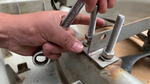 View of technician hand loosening a nut on a threaded rod Stock Footage 346360226