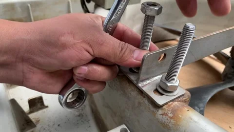 View of technician hand loosening a nut on a threaded rod Stock Footage 346812920