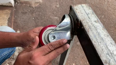 View of a technician hands installing a trolley wheel Stock Footage 346813038