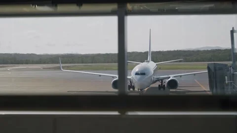View from terminal gate window on airplane arriving at airport tarmac or runway Stock Footage 320359582
