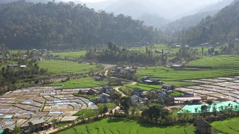 View of terraced fields and a village in a lush valley, Nepal. Vídeo Stock 335604173