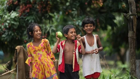 View of three children laughing in a lychee orchard in Bangladesh. Stock Footage 335584259