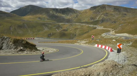 View of three longboarders riding on a beautiful day on Transalpina Stock Footage 57798543