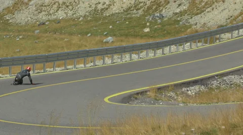 View of three longboarders speeding and braking in curves of Transalpina Video stock 57788626