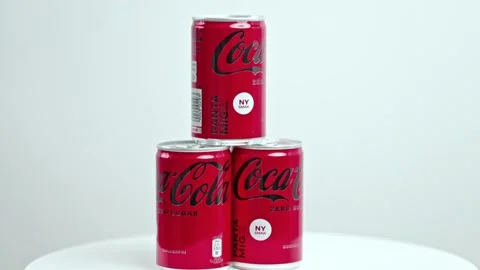 View of three metal can of sugar-free Coca-Cola rotate in background. Stock Footage 223871883