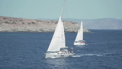 View of three sailing boats crossing a wavy open sea Stock Footage