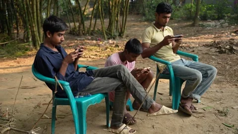 View of three young men using smartphones in Bogura, Bangladesh. Video stock 335025098