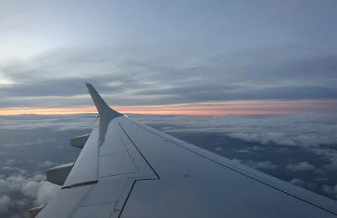 View through aeroplane window at dust showing sun setting Stock Photos