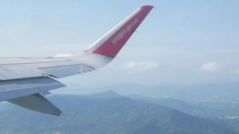 View through aircraft window with plane's wing over blue sky with white flu.. Stock Footage 283055339