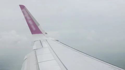 View through aircraft window with plane's winglet over blue sky with white .. Stock Footage 283055921