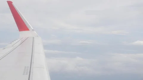 View through aircraft window with plane's winglet over blue sky with white .. Stock Footage 297459409
