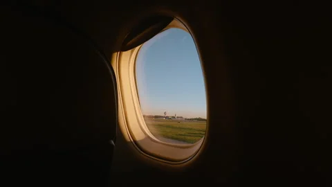 View through airplane porthole during flight with clear sky and warm sunlight Stock Footage 340448577