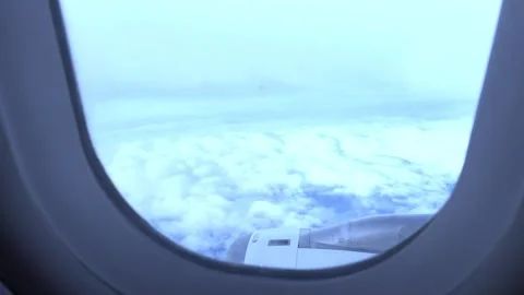 View Through Airplane Window Above a Cloudy Sky, Aerial 4K Video Stock Footage 346555694