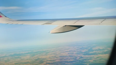 View through an Airplane window. Aircraft wing sky and land 库存影片 112797800