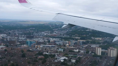 View through an Airplane window. Aircraft wing sky and town Stock Footage 112816994