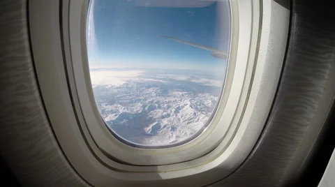View through an airplane window the airplane wing above snow mountains -Dan Stock Footage 46861762