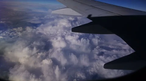 View through an airplane window in the blue sky in clouds Stock Footage 68769712