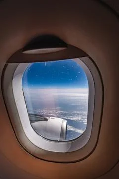 View through airplane window during flight on a Sunny day with cloudy sky Stock Photos