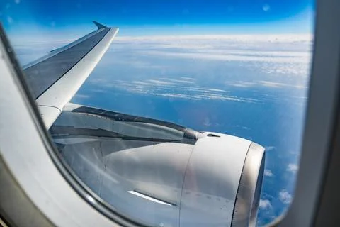 View through airplane window during flight on a Sunny day with cloudy sky Stock Photos