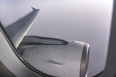 View through airplane window during flight on a Sunny day with cloudy sky Stock Photos