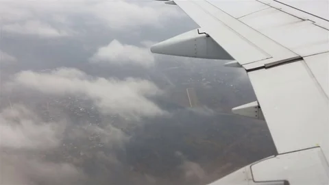 View through an airplane window. Flying over the city through clouds Stockbeeldmateriaal 80521649