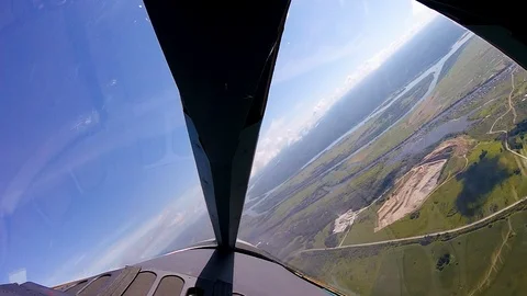 View through airplane window porthole with cultivated fields near the blue sky Stock Footage 120001233