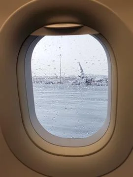 View through an airplane window on a rainy day with raindrops covering the glass Foto stock