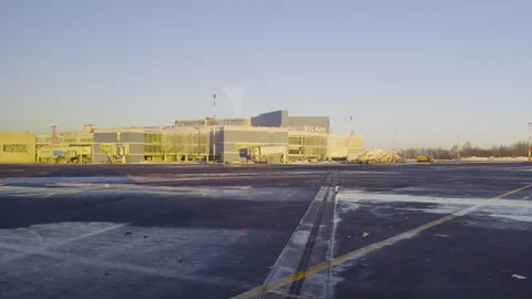 View through an airplane window shows the airport apron and runway passing by as Video stock 342812340