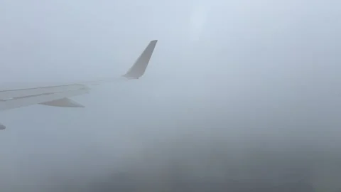 View Through Airplane Window Turbulence Dense Clouds Flight Plane Blue Wing Stock Footage 319593108