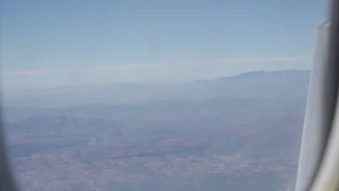 View through airplane window while flying over mountain range over Kunming .. 库存影片 329669782