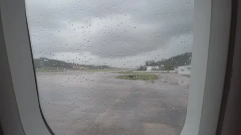View through airplane window while taxing in airport while raining outside .. Vídeo Stock 337929213