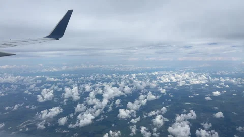 View Through Airplane Window. Wide Above the Clouds Blue Wing Cloudy Day Stock Footage 319593094