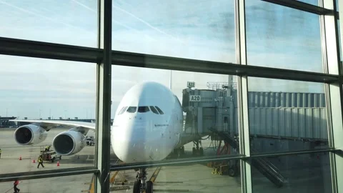 View through airport terminal window of huge aircraft waiting at gate as Video stock 130405605