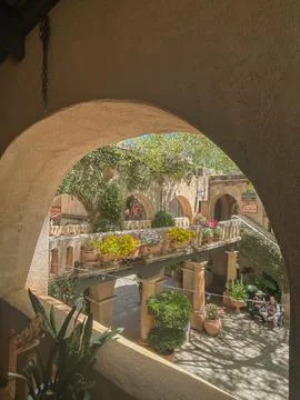 View through arch of sunlit courtyard with flowers in Sedona, Arizona Stock Photos