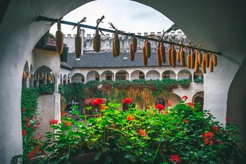 View through an archway of a courtyard with corn drying on a line.  The walls Stock Photos