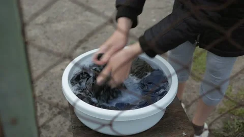 The view through the bars, female hands, wash clothes in a basin with detergent. Stock Footage 131735496