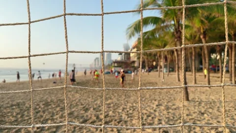 View through Beach Volleyball Net with Players in blurred Background at Tropical Vidéo 342581819