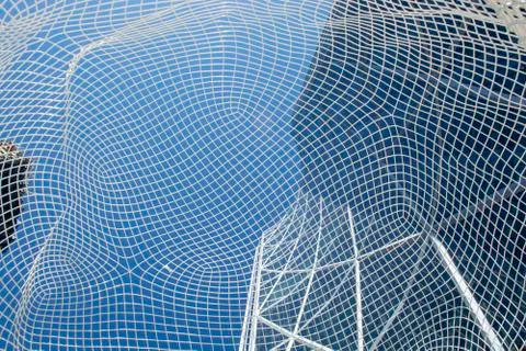 View through big mesh head public art display in front of office tower Stock Photos