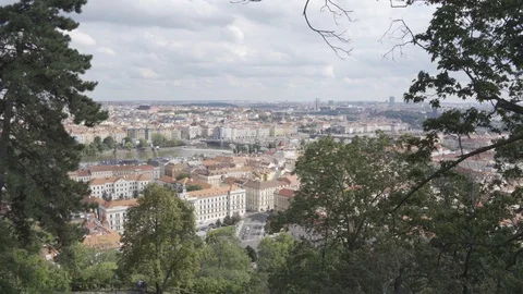 View through the branches of trees above the capital city of Prague Stock Footage 115766521