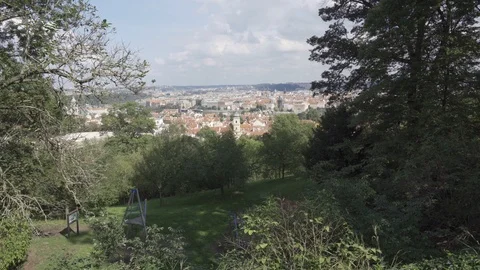 View through the branches of trees and garden above the capital city of Prague Stock Footage 115766444