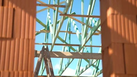 View through brick wall opening showing wooden roof trusses under blue sky Stock Footage 310357052