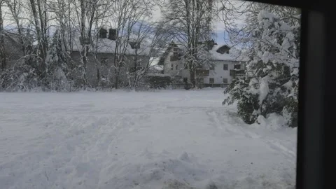 View through bus window in snowy Munich, Germany, reveals streets blanketed in Stock Footage 318977994