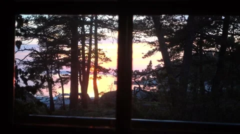 A view through cabin window to the sea with the setting sun Stock Footage 64840829