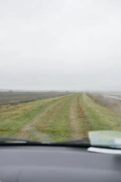 View through the car window on an empty meadow. Fisherman goes fishing. Stock Photos