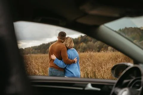 View through the car window, a man and a woman are embracing each other, adult Фото