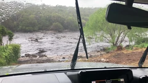 A view through a car windscreen in the rain over a river in full flood Stock Footage 334030473
