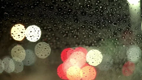 A view through a car windshield during a rainy night drive, with blurred city Stock Footage 276398047