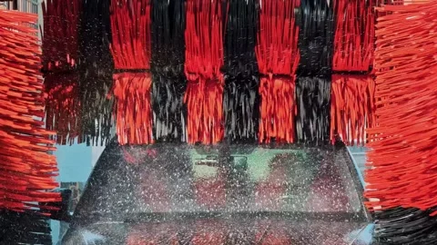 View through car windshield inside automatic wash. Streams of water and foam Stock Footage 330740689