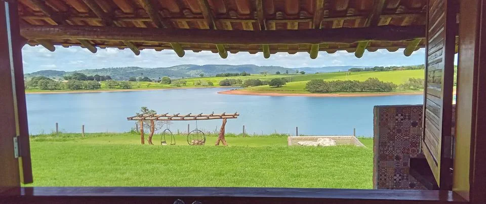 View through a chalet window to the dam and surrounding fields Stock Photos
