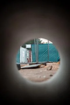 View Through Circular Pipe Framing a Construction Site with Trees Stock Photos